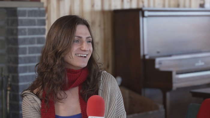 Xénia Gould tient un micro.