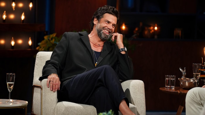 Jean-Philippe Wauthier rit, assis dans un fauteuil du décor de « Bonsoir, bonsoir ».