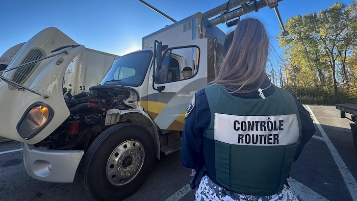 Un véhicule lourd en train de se faire inspecter par un contrôleur routier.