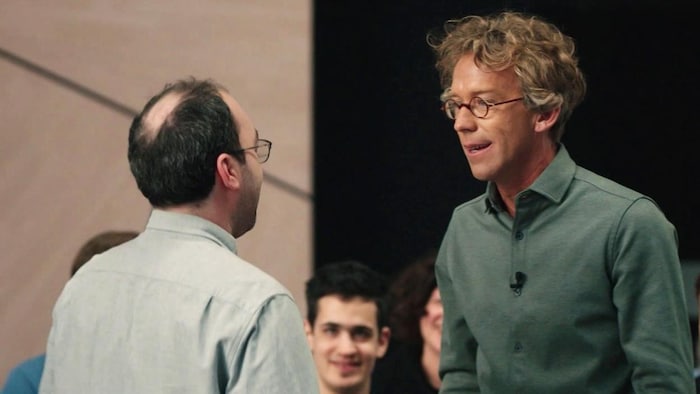 Fred Pellerin est face à une personne et ils parlent.