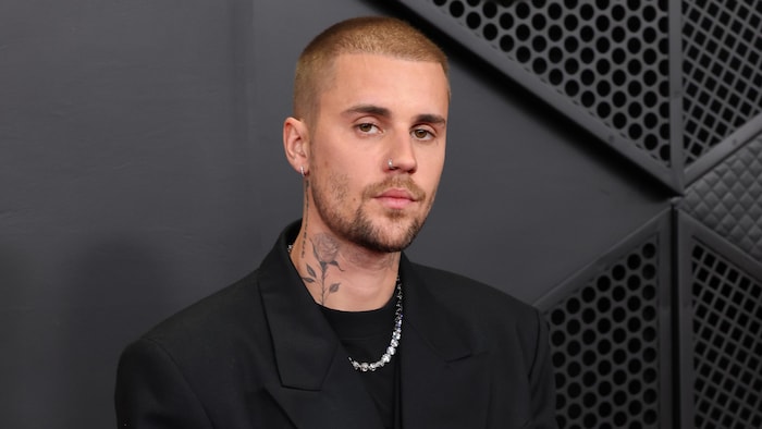 Justin Bieber prend la pose, vêtu d’un complet noir avec un petit macaron blanc qui porte le message « ICE Out ».