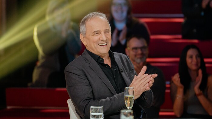 Un homme applaudit sur un plateau de télévision