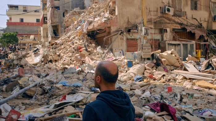 Un homme est entouré de ruines.