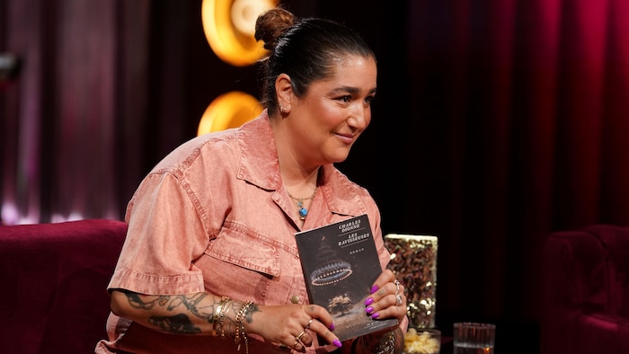 Mariana Mazza tient un livre sur le plateau de Bonsoir bonsoir.
