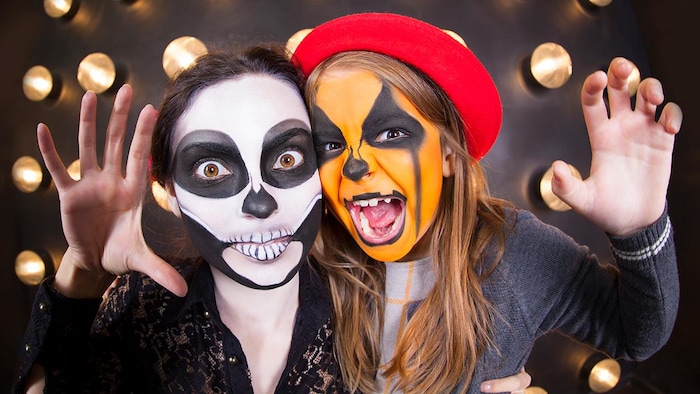 Deux filles déguisées en squelette et en citrouille. 