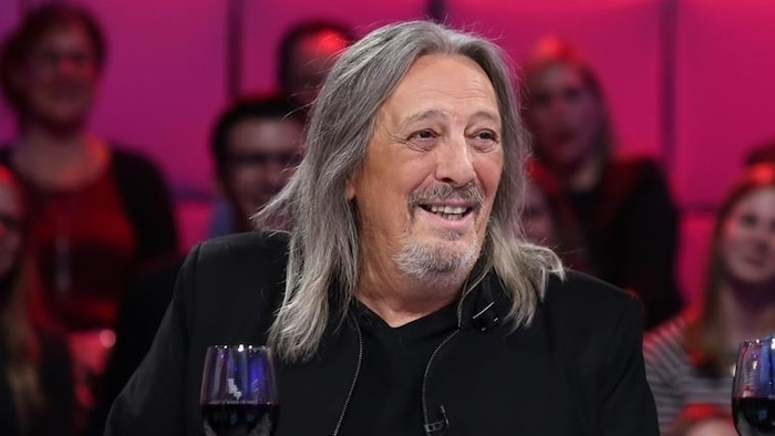 Serge Fiori sourit, sur un plateau de télévision.
