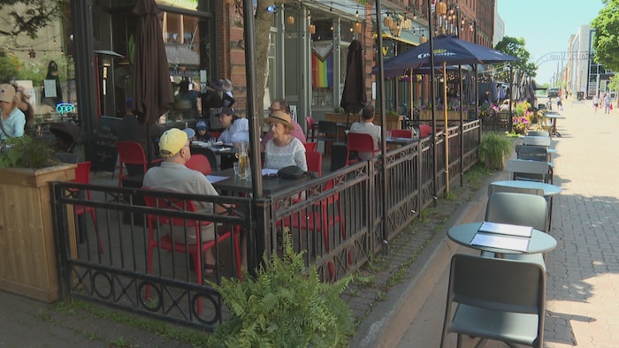 Des clients boivent une bière à la terrasse d'un restaurant.