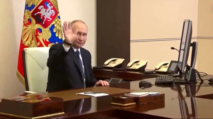 Vladimir Poutine envoie la main dans un bureau.