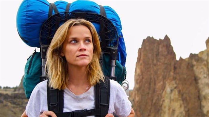 Une femme (Reese Witherspoon) portant un sac à dos de camping.