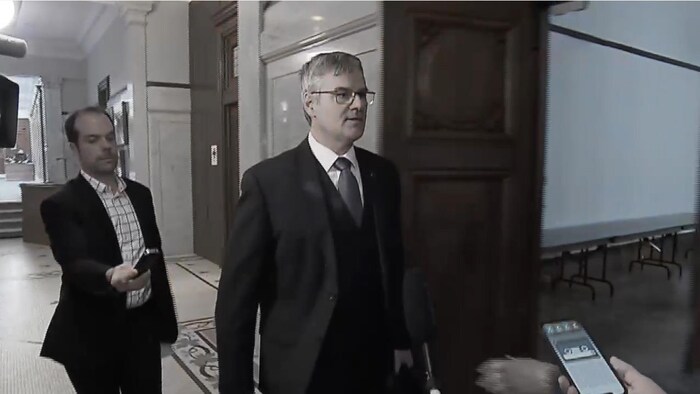 Éric Caire marche dans un corridor de l'Assemblée nationale.