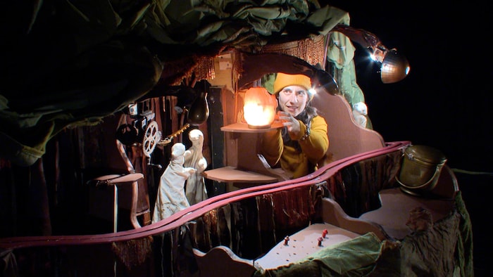 Un acteur approche sa main d'une lumière. 