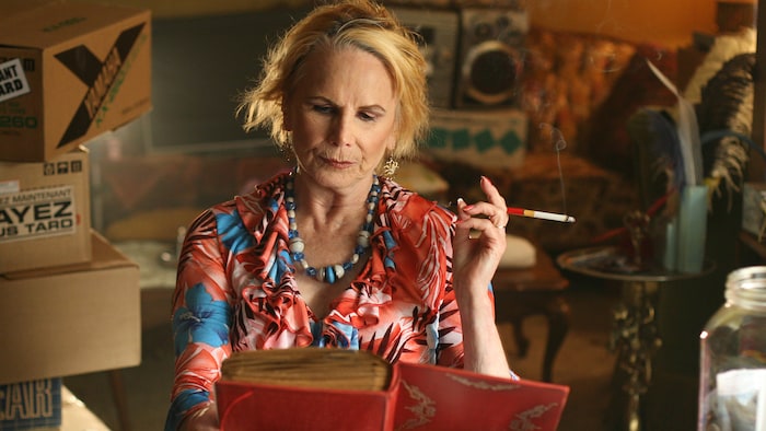 Une femme fume une cigarette en lisant un livre.