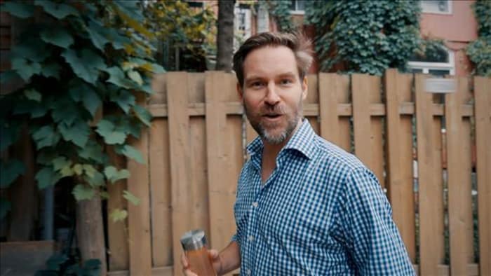 L'homme s'exprime devant une clôture en bois.