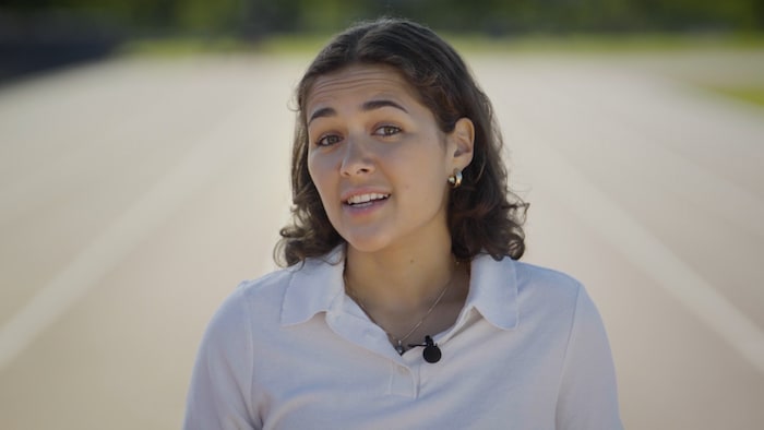 Julia Pagé parle sur une piste. 