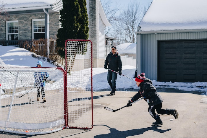Jérôme joue au hockey avec ses fils Nathan et Pier-Olivier, devant leur maison à Trois-Rivières.