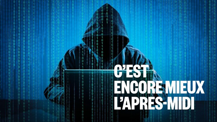 Un homme masqué devant un ordinateur.
