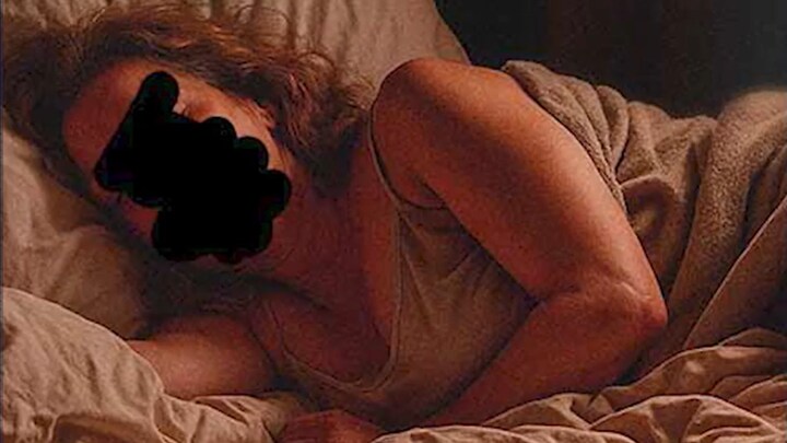 Une femme couchée dont le visage est caché.