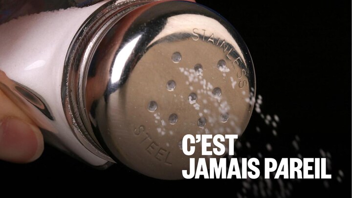 Une personne ajoute du sel à une recette.