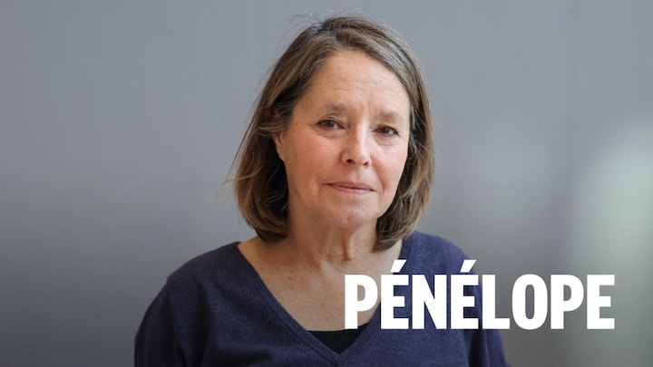 Michèle Ouimet est devant un mur gris dans l'atrium de Radio-Canada.