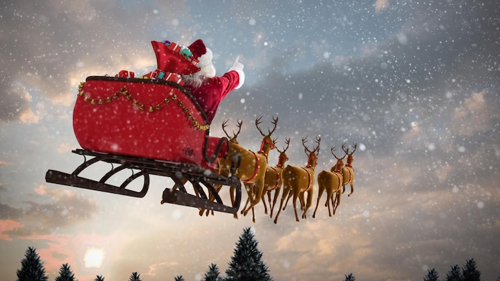 Une image du père Noël dans le ciel installé dans son traineau et guidé par les rennes.  