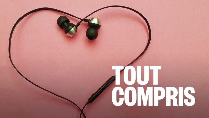 Des fils d'écouteurs forment un cœur sur un fond rose.