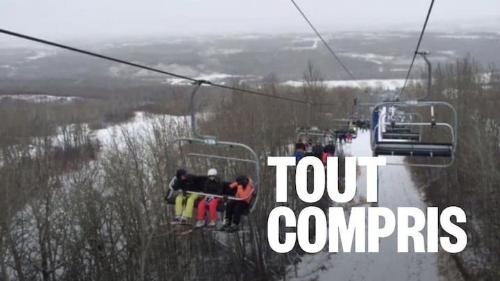 Des personnes assises sur un télésiège dans une station de ski.