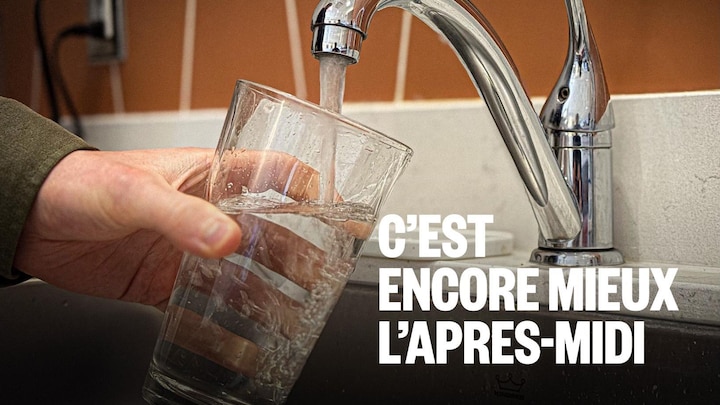 Une personne remplit un verre d'eau.
