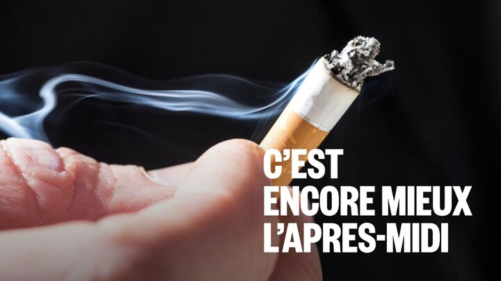 Une main tient un mégot de cigarette allumée.