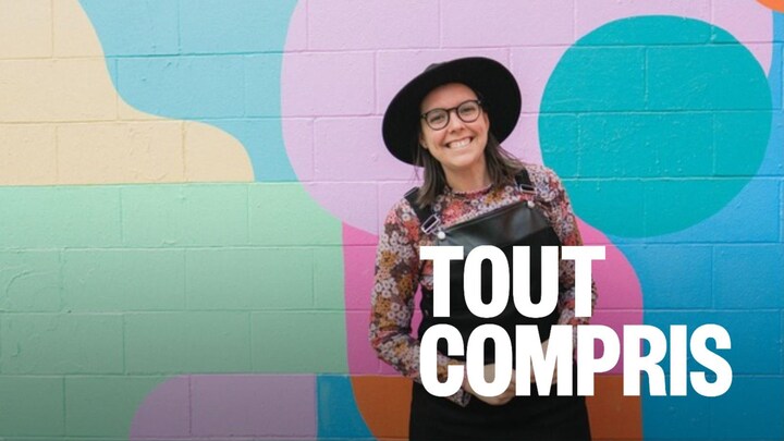 Une personne qui sourit devant une muraille.
