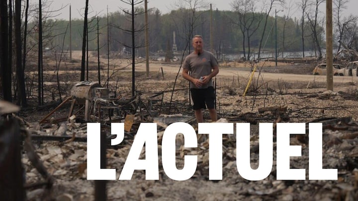 Un homme se tient debout au milieu d'un tas de ruines.