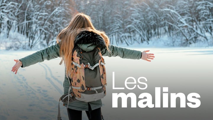 Vue de dos d'une femme qui marche sur un sentier en hiver. Elle a les bras tendus aux côtés d'elle.