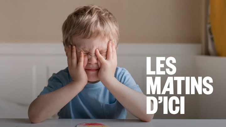 Un jeune garçon qui tient sa tête dans ses mains. Il semble très stressé.