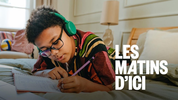 Un jeune garçon qui fait ses devoirs en écoutant de la musique.