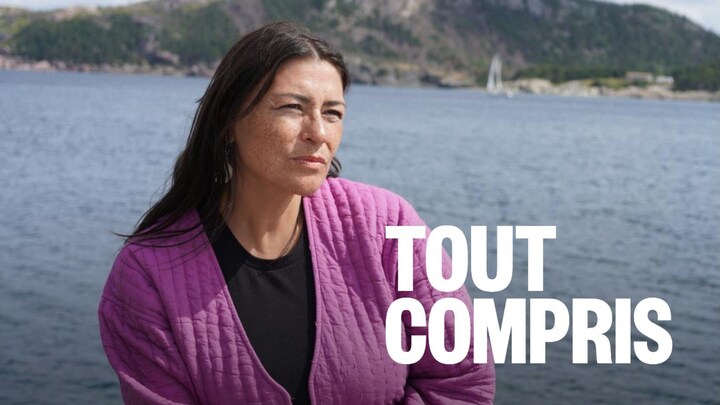  un voilier sur l'eau avec des collines derrière.