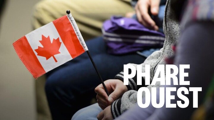 Une personne tient un petit drapeau du Canada.