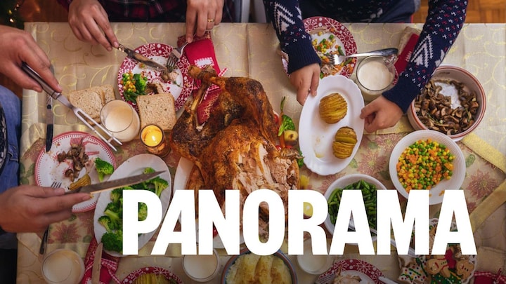 Vue de haut d'une table sur laquelle une famille mange un gros repas de temps des Fêtes.