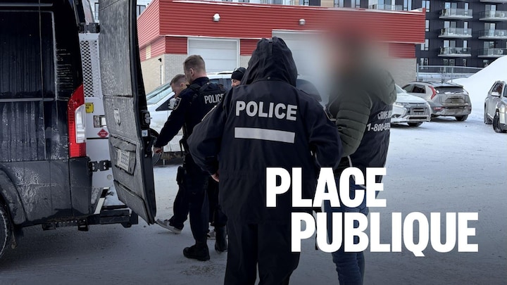 Des policiers escortent un homme dans un véhicule.