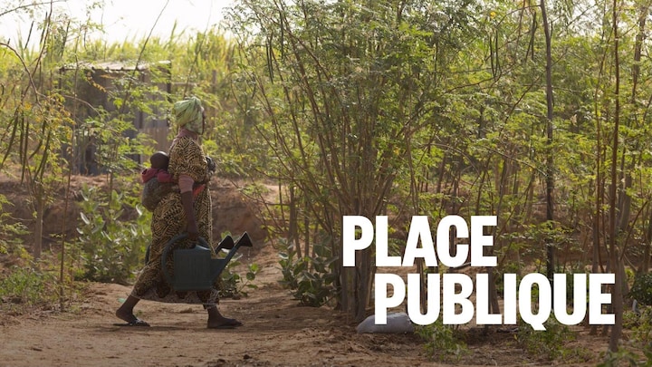 Une femme marche près d'arbres au Sénégal.