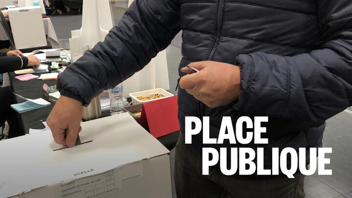 Un électeur dépose son bulletin de vote dans une boîte de scrutins.