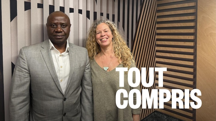 Deux personnes, un homme et une femme, debout dans le studio de Radio-Canada à Regina