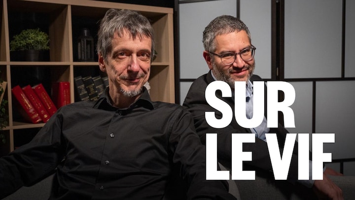 Dreux hommes souriants qui posent assis sur des fauteuils.