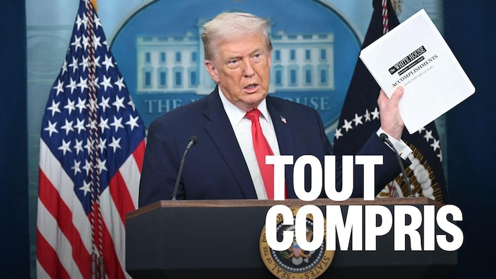 Donald Trump au lutrin de la salle de presse de la Maison-Blanche, tenant un document disant « Accomplissements ».