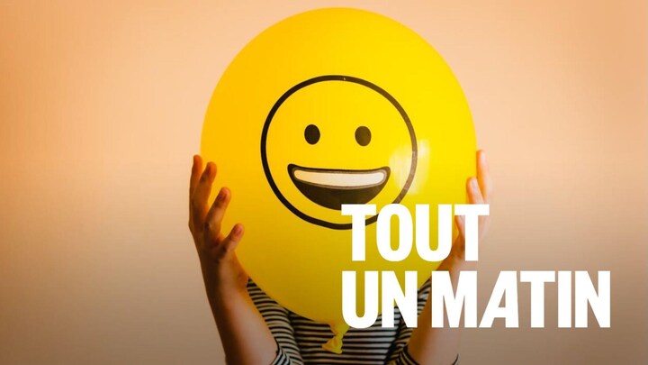 Une personne tient devant elle un ballon avec un bonhomme sourire.