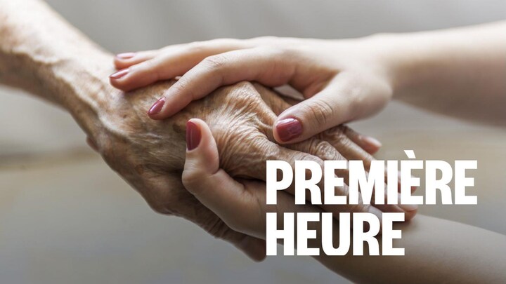 Une femme plus jeune tient la main d'une femme âgée.