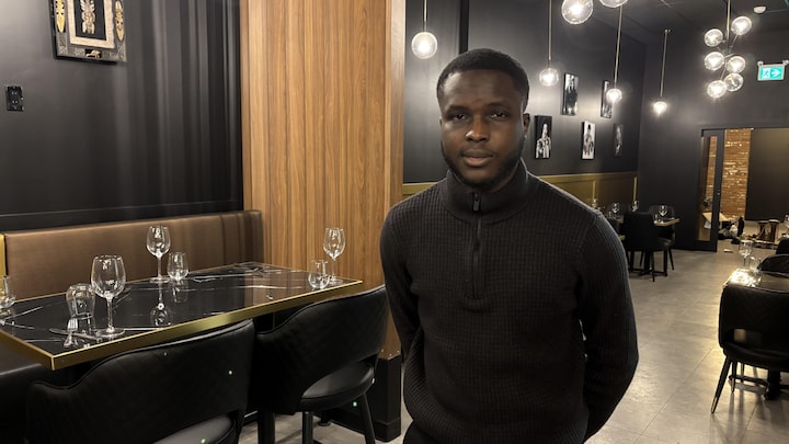 Un homme debout dans un restaurant.
