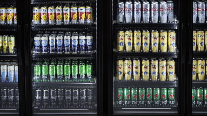 Des canettes de bière dans le réfrigérateur d'un commerce