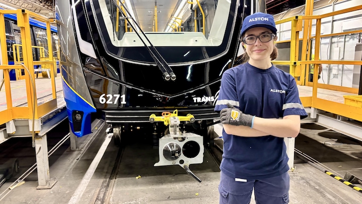 Bruna Rodrigues Moreira sourit à la caméra devant un wagon du Skytrain de Vancouver.