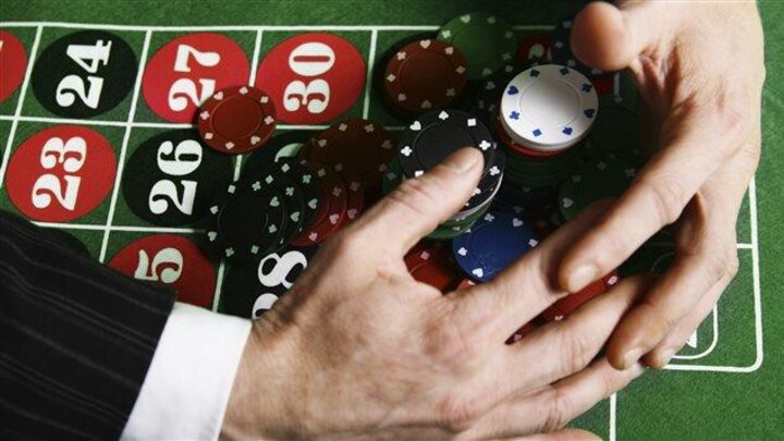 un tapis de jeu de casino avec des jetons, des mains en train de se saisir de tous les jetons