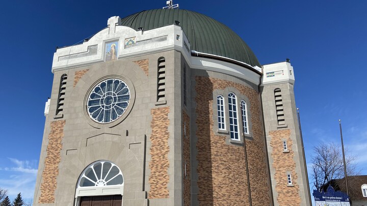 Façade de la cathédrale d'Amos, une grande bâtisse en pierres et munie d'un dôme.