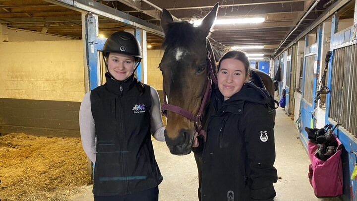 Deux jeunes filles posent avec un cheval.